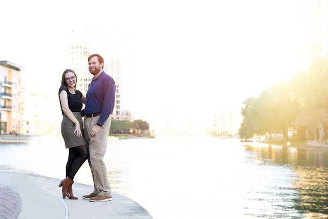 Leila and Dante stand by a river at sunset.